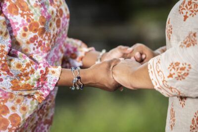Dos mujeres estrechándose las manos, dándose apoyo mutuo